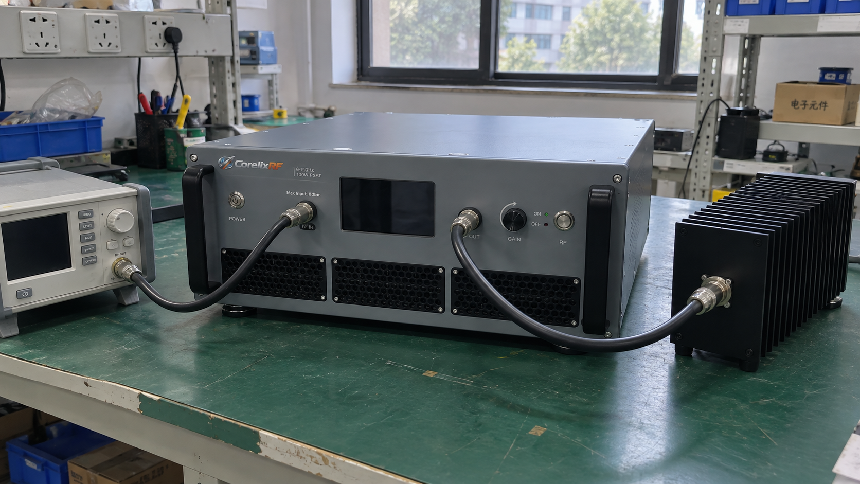 Rack power amplifier with input cable and an output cable connected to a passive finned RF load on a workshop bench