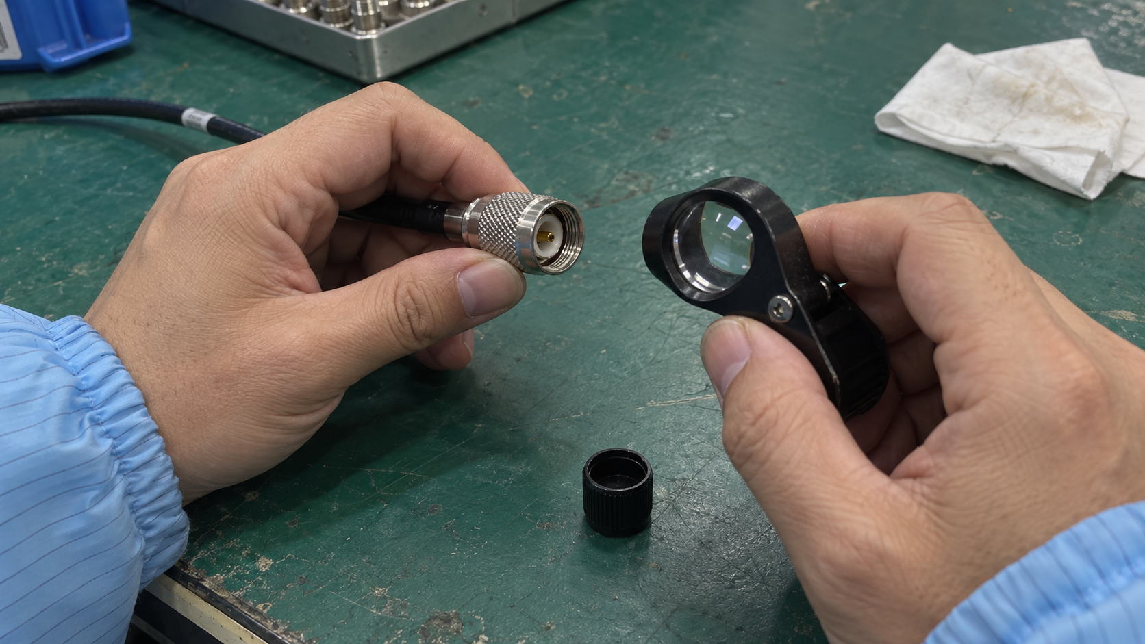 Close-up of a technician inspecting an unconnected precision coaxial cable connector