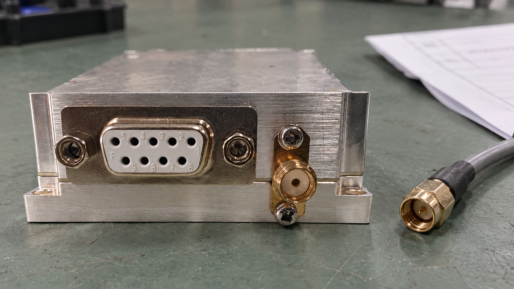 Close-up of an amplifier control connector and RF socket beside an unplugged coaxial cable.