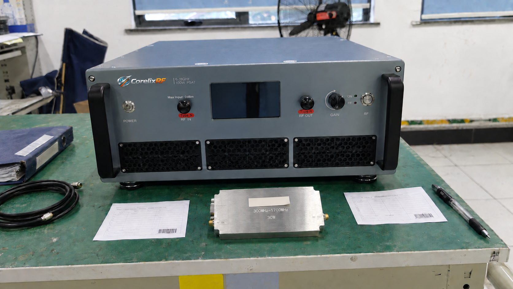 Rack amplifier and compact amplifier module with separate record cards on a workbench.