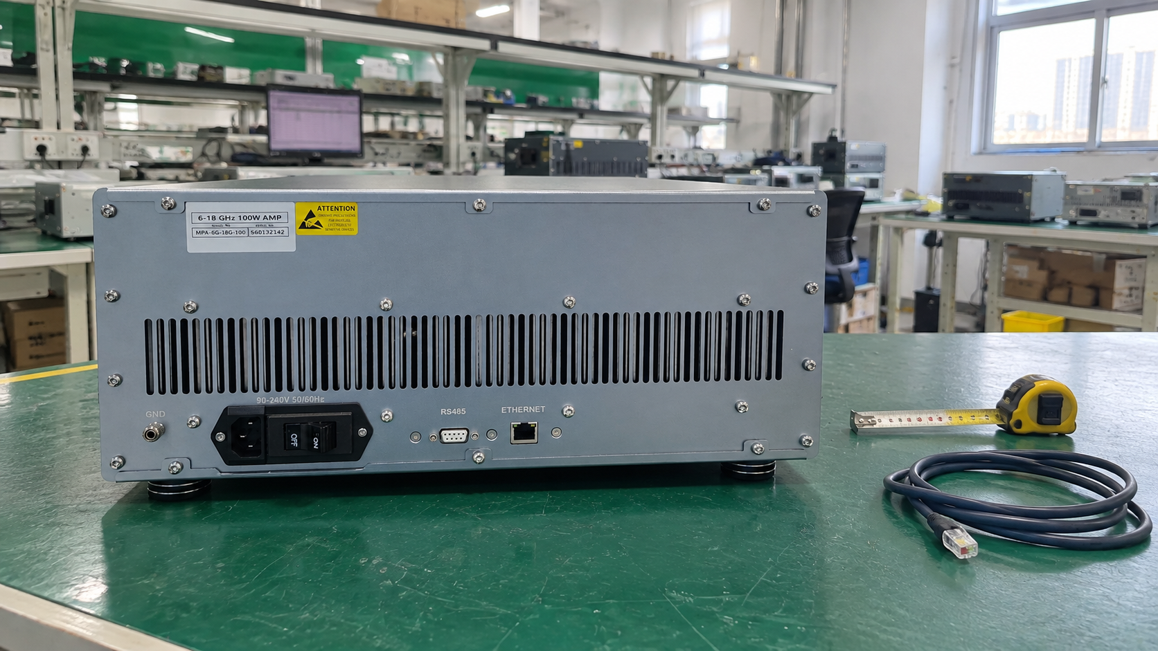 Rear panel of a closed CorelixRF rack amplifier with control interfaces, an unplugged Ethernet cable and a tape measure on the workbench